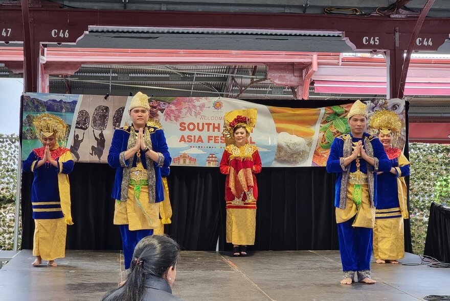 A cultural dance performance taking place on a small stage as part of the South East Asia Festival, at the Queen Victoria Market.