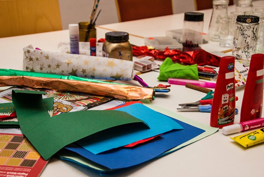 An assortment of craft materials on a table with a Christmas theme. 