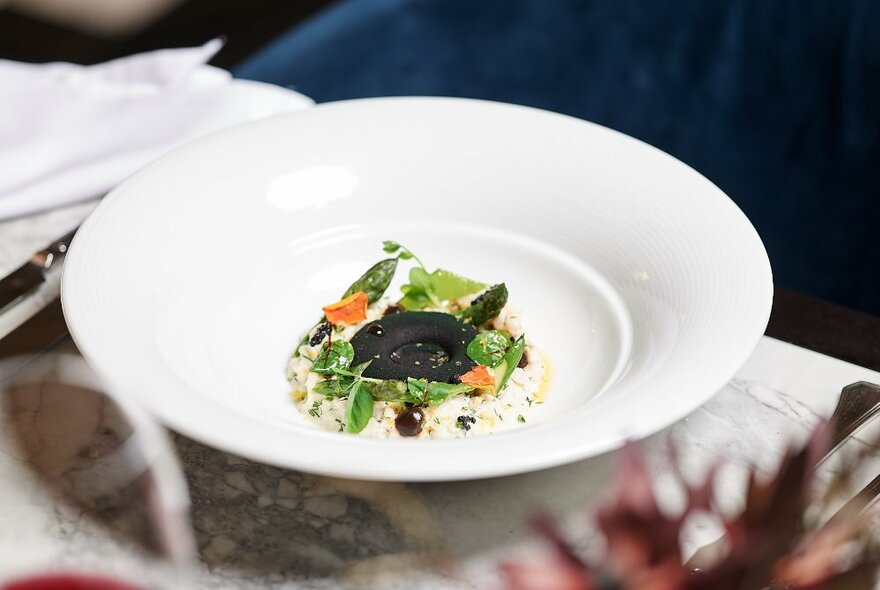 Large white plate with a delicately arranged meal on it.