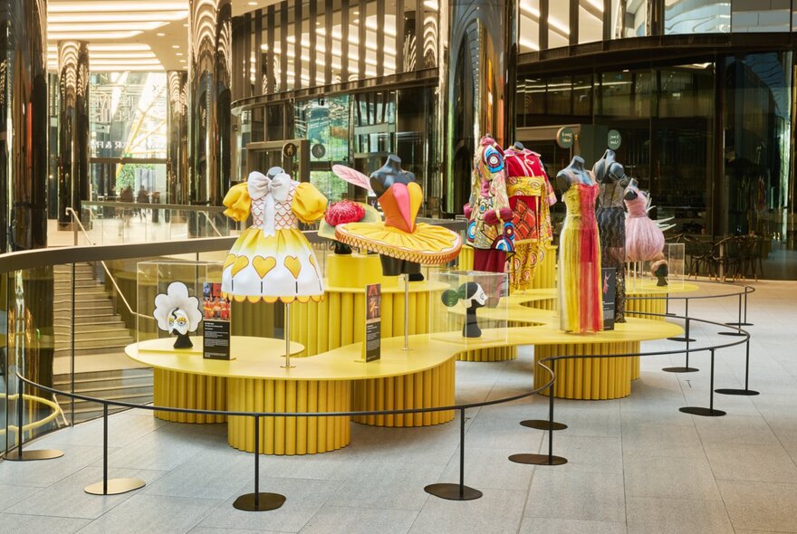A yellow-coloured display of clothing and costumes in a shopping centre.