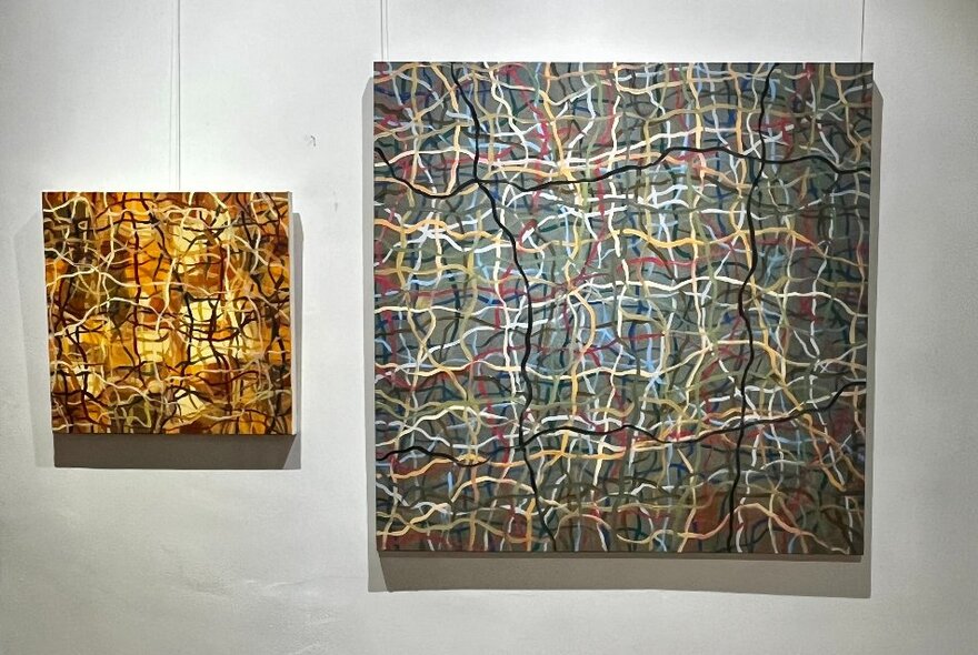 A gallery wall showing two works by artist Matthew Simpson, both a tangle of coloured lines. 