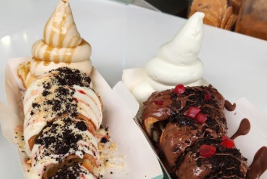 Two long paper plates with desserts and ice cream.