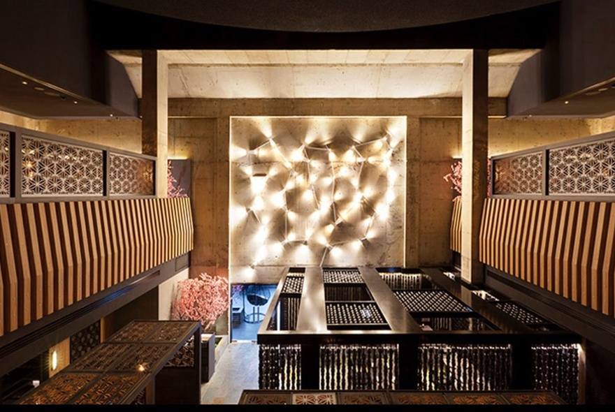 Traditional Japanese dining room with wooden screens, seating and tables.