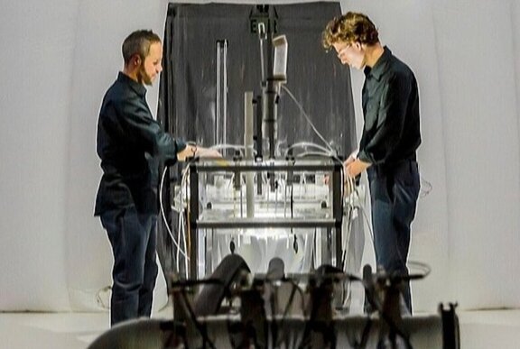 People standing at illuminated instrument table.