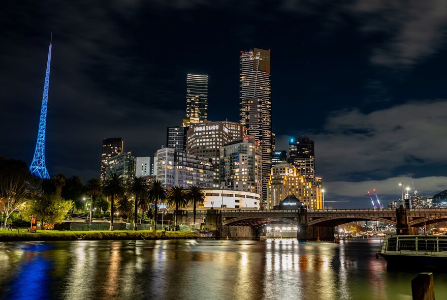 Melbourne city skyline at night with the Yarra River in the foreground.