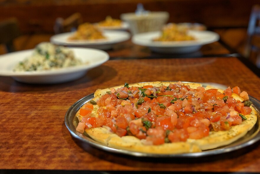 Margarita pizza with chopped tomato topping.