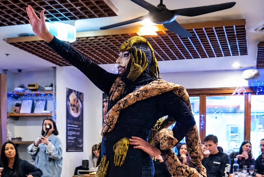 A drag queen performing in a restaurant setting.