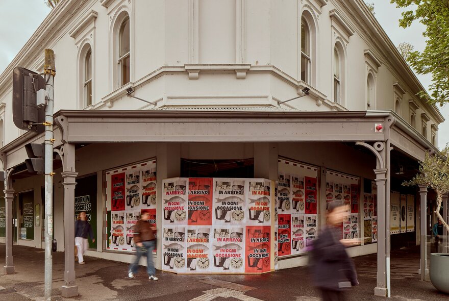 The exterior of a corner building covered in posters.