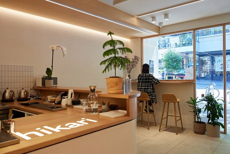 Person sitting on a stool in Hikari Japanese coffee shop.