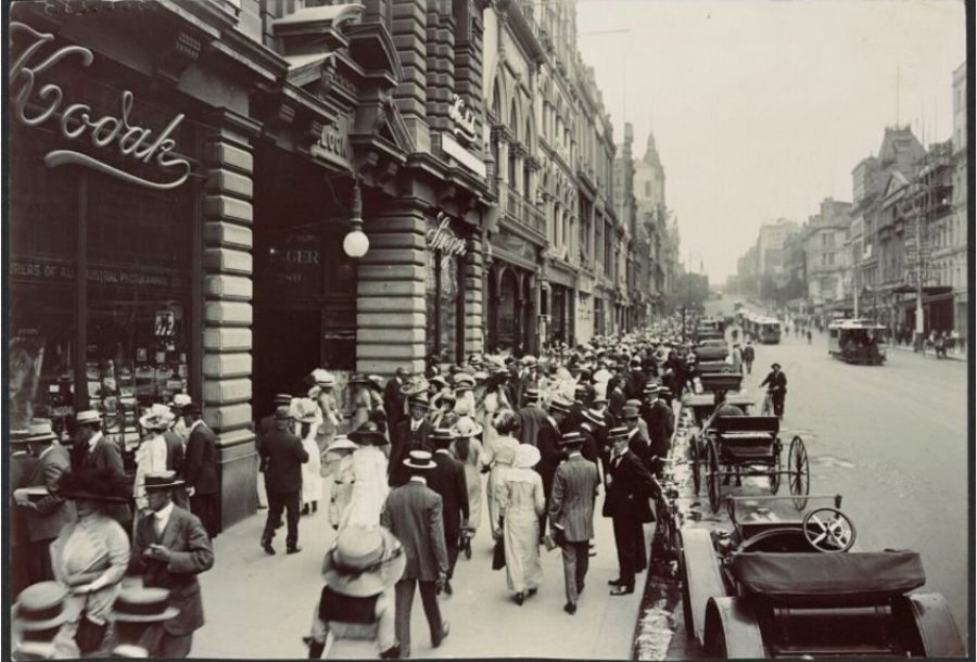 A black and white photo of a busy shopping street