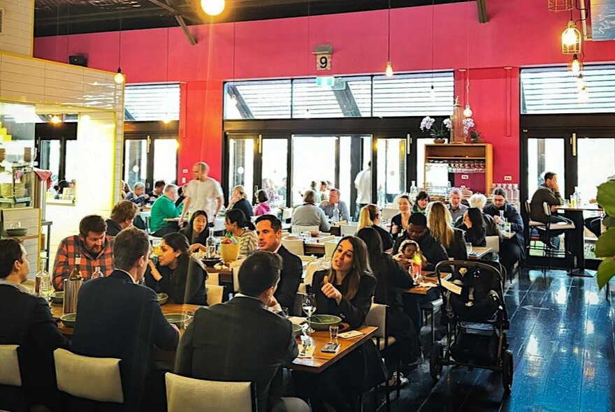 A full restaurant with pink walls and blue floor.