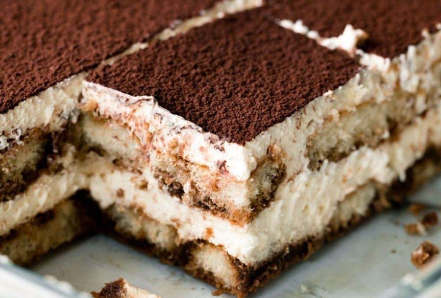A square slice of tiramisu in a cake tray.