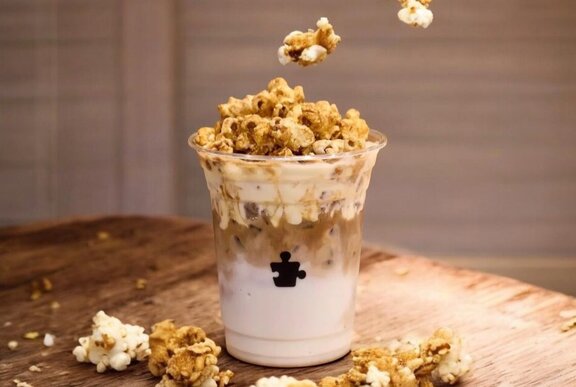 An iced latte with popcorn on top.