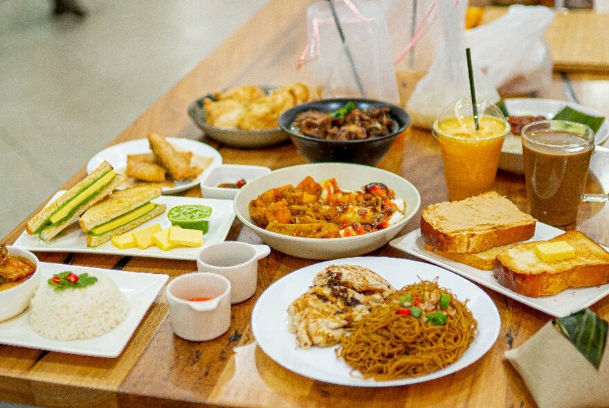 A table set with many small plates of Malaysian food. 