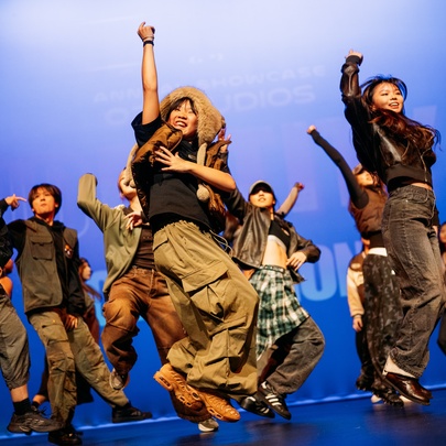 Dancers performing on stage, leaping into the air at once.