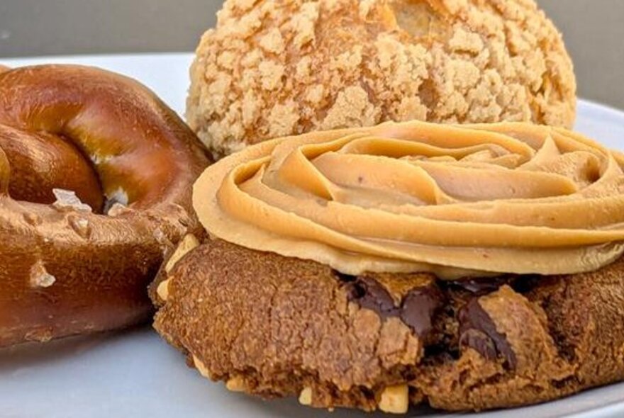 Close-up of biscuits and cookies, one of them topped with whipped peanut butter.