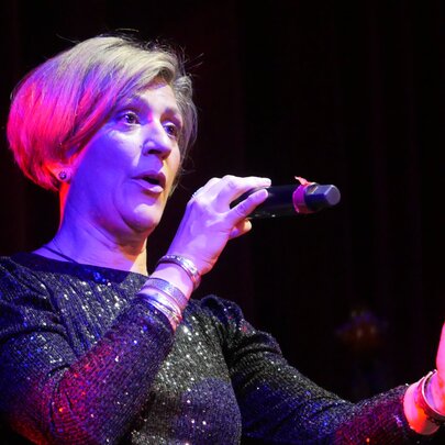 Acclaimed French chanteuse Noria Letts singing into a microphone.