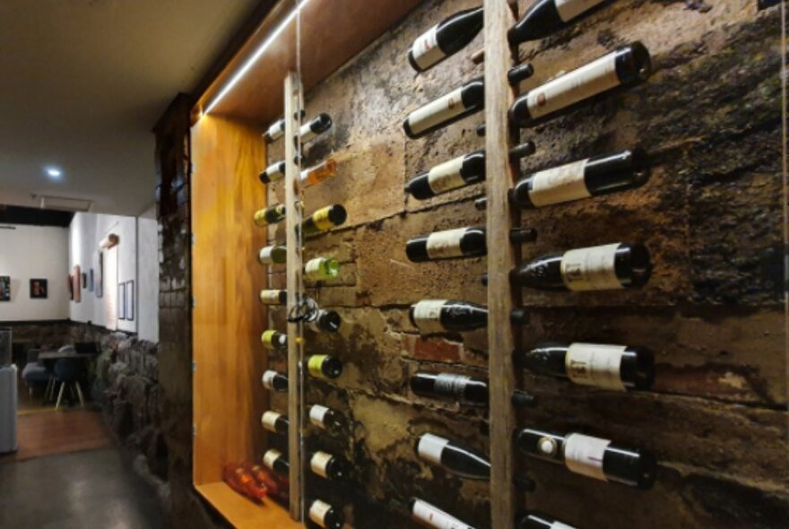 A cellar with wine bottles on the walls. 