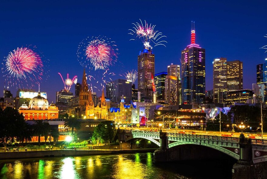 City skyline from Princes Bridge, with fireworks exploding in the night sky.