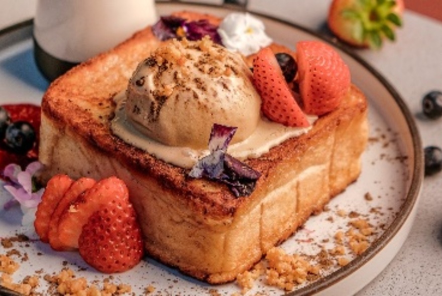 A plate of Japanese Hojicha hazelnut toast with ice cream and strawberries. 