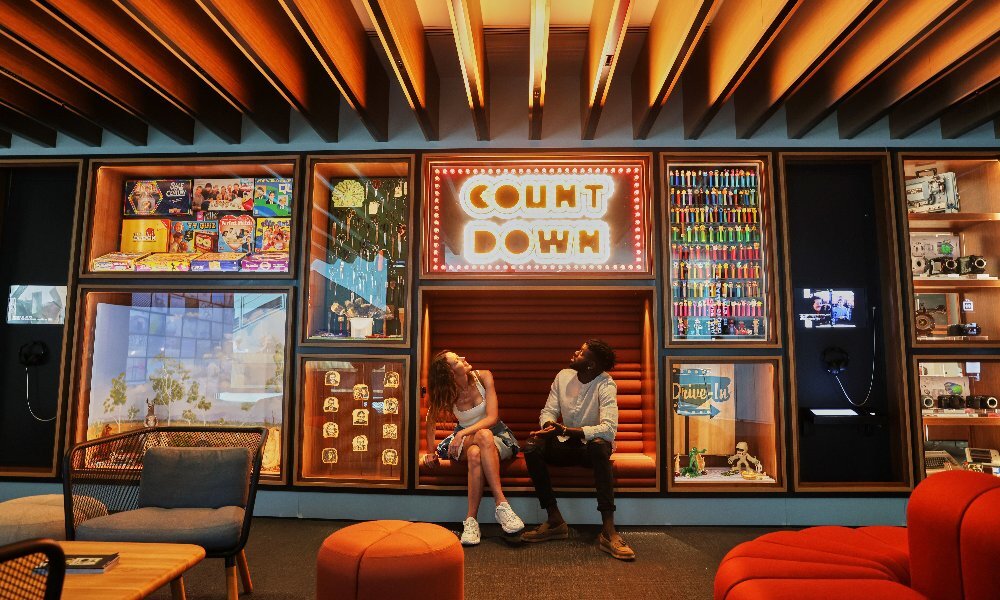 A couple in a gallery looking up at a sign that says count down.
