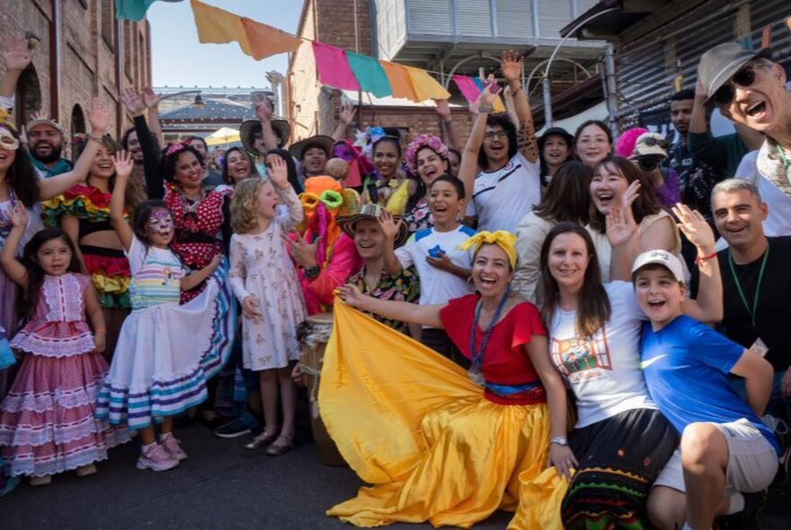 A group of smiling, happy people posing for a photo, with a colourfully-dressed flamenco dancer in the front.
