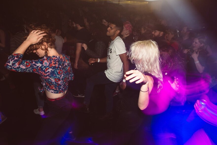 People dancing at a nightclub in a crowded nightclub.