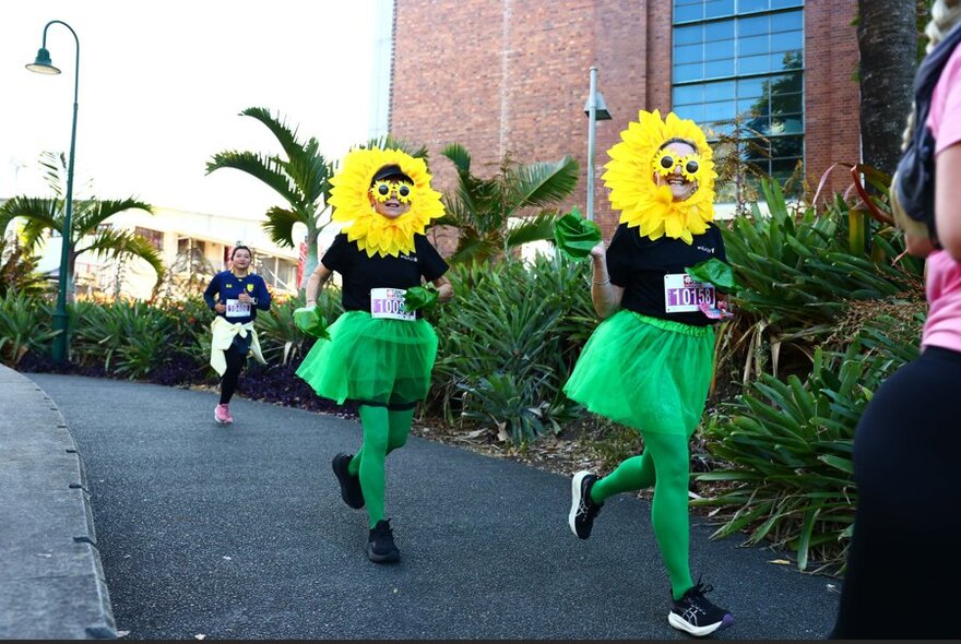 Two people dressed as sunflowers during a charity fun run. 