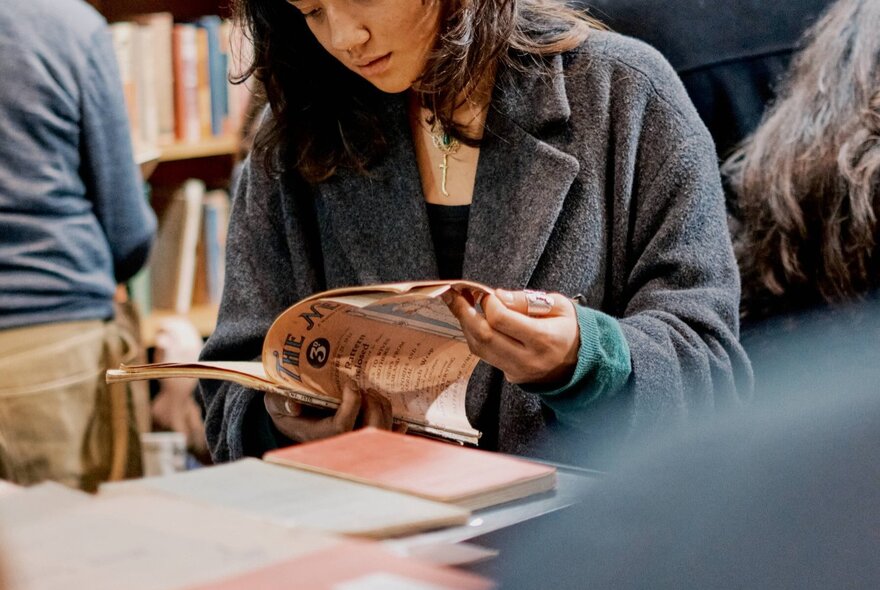 A person flicking through a vintage magazine at the Rare Book Fair.