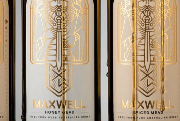 The gold-embossed labels of two wine bottles from Maxwell Wines.