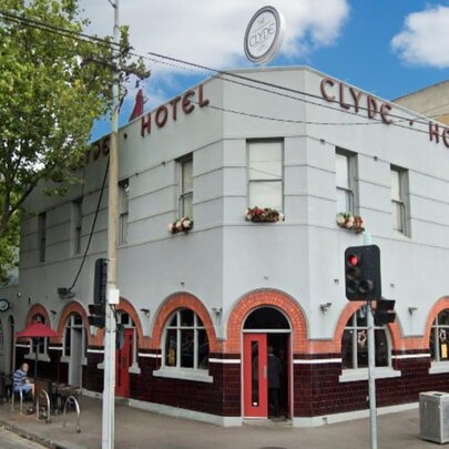 Carlton corner pub with arched tile details and signage.