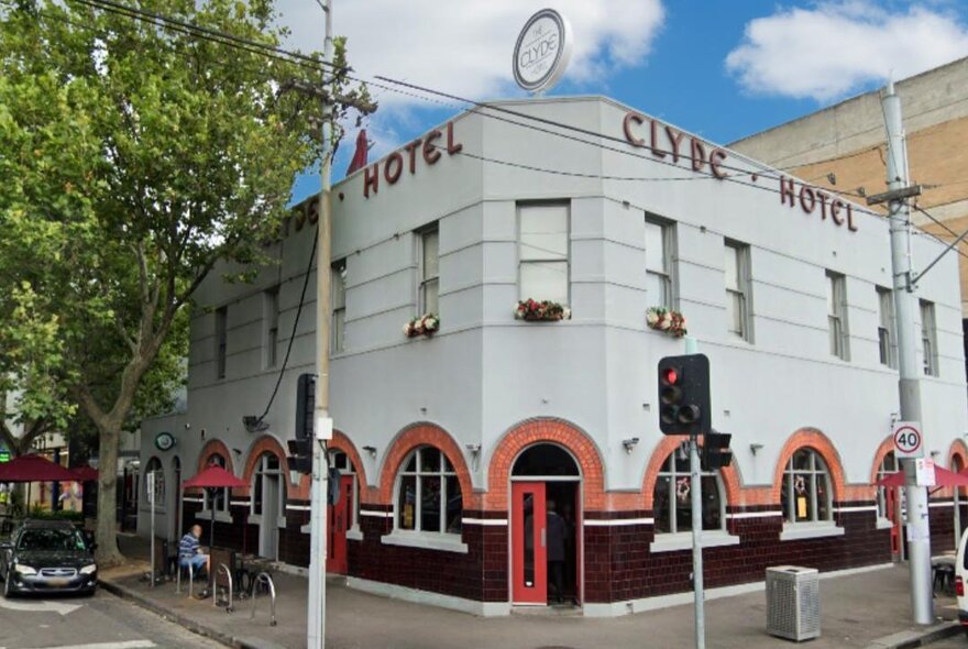 Carlton corner pub with arched tile details and signage.