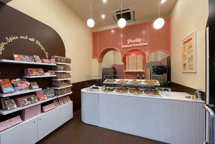 Interior of The Confectionist Bakery store with a service counter and a wall of packaged cookie products.