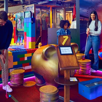 A group of four friends playing mini golf.