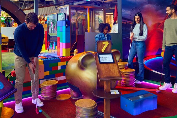 A group of four friends playing mini golf.