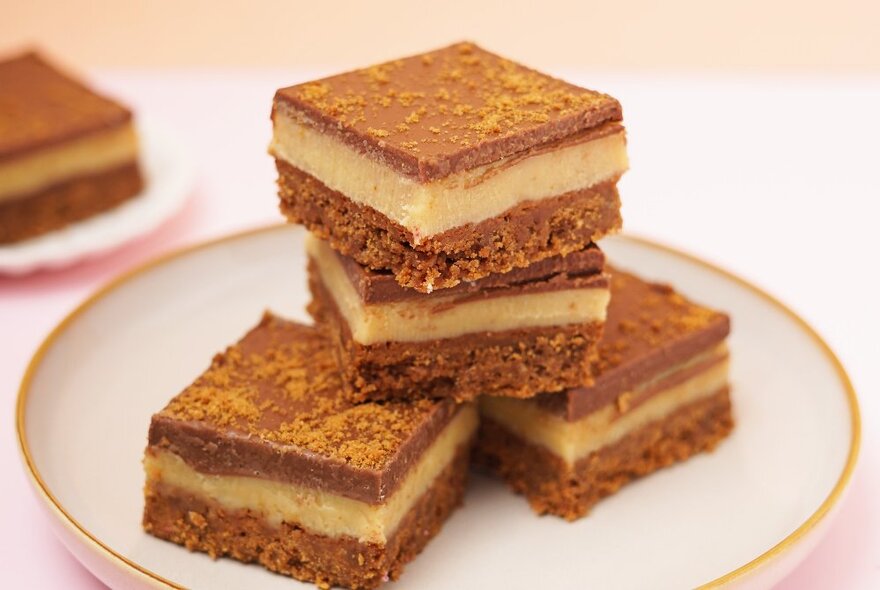 A white plate with four serves of stacked dessert slices. 