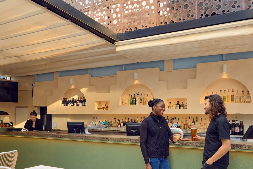 Two friends are drinking at a bar.