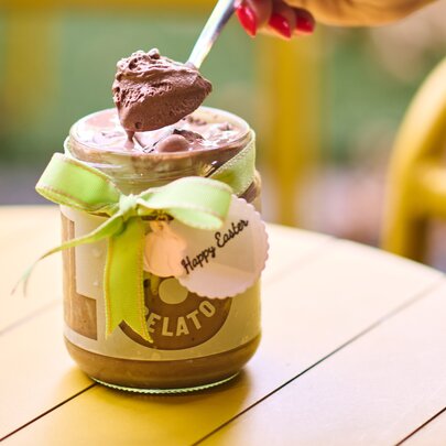 a person is spooning gelato out of a jar
