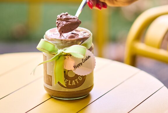 a person is spooning gelato out of a jar