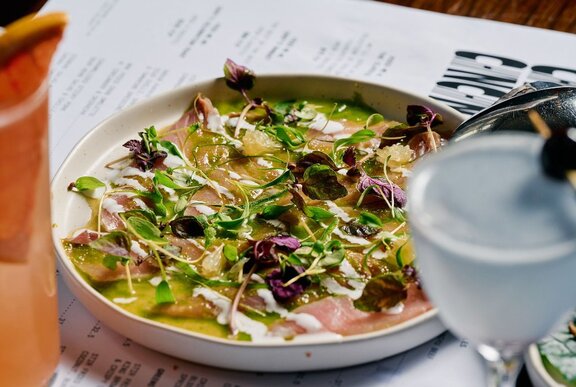 A plate of kingfish ceviche with a small martini served alongside.