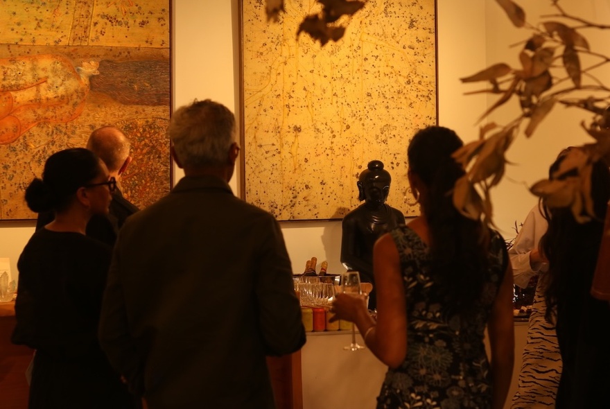 People looking at artworks in a gallery space.