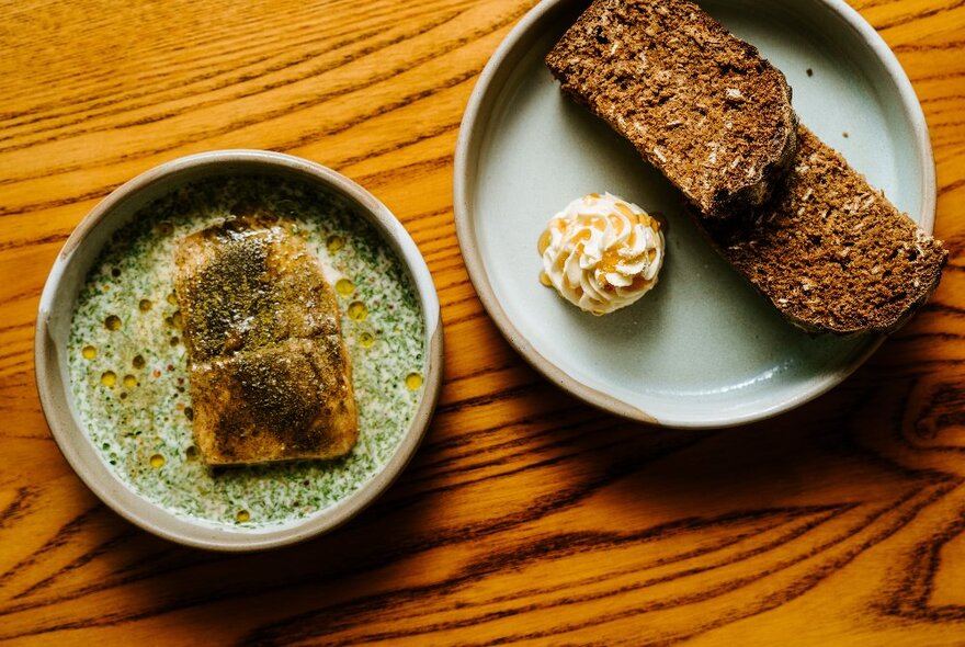 Looking down at two plates of food on a wooden table.