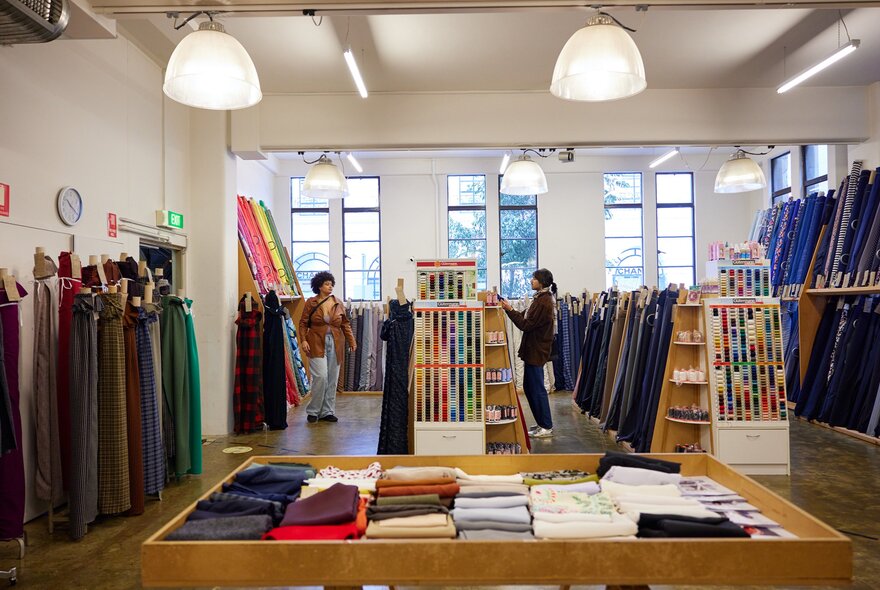Two friends are browsing fabrics in a fabric store