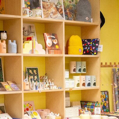 Yellow shelving and walls in a shop that sells cute knickknacks. 
