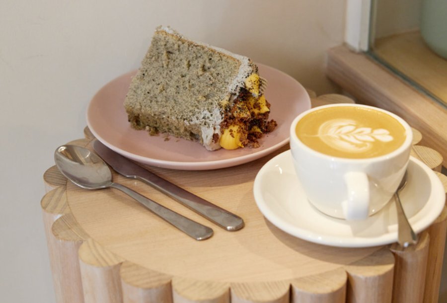 Coffee and cake on a round wooden table.