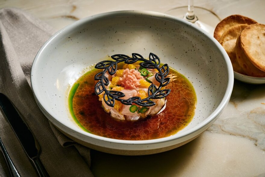 A shallow bowl of food, on a restaurant table.