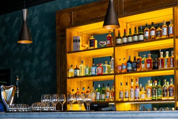 Shelves of alcohol at a bar.