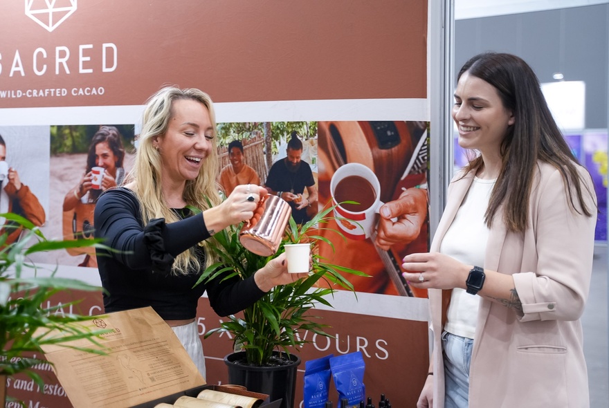 A stall at the MindBodySpirit Festival  where ceremonial cacao is being prepared and served to people visiting the stall.