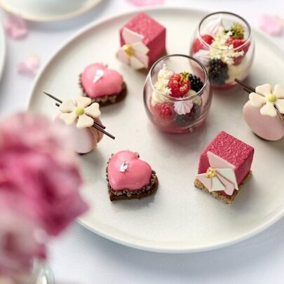 Pink cakes on a white plate with pink flowers.