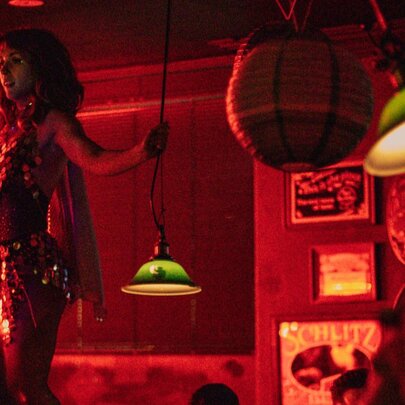 Drag performer hosting bingo in the dimly lit Heartbreaker Bar.